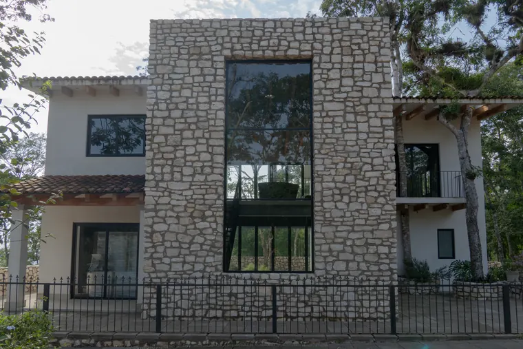 Fachada frontal de la primera casa de San Lorenzo, con su torre de piedra y ventanal de doble altura